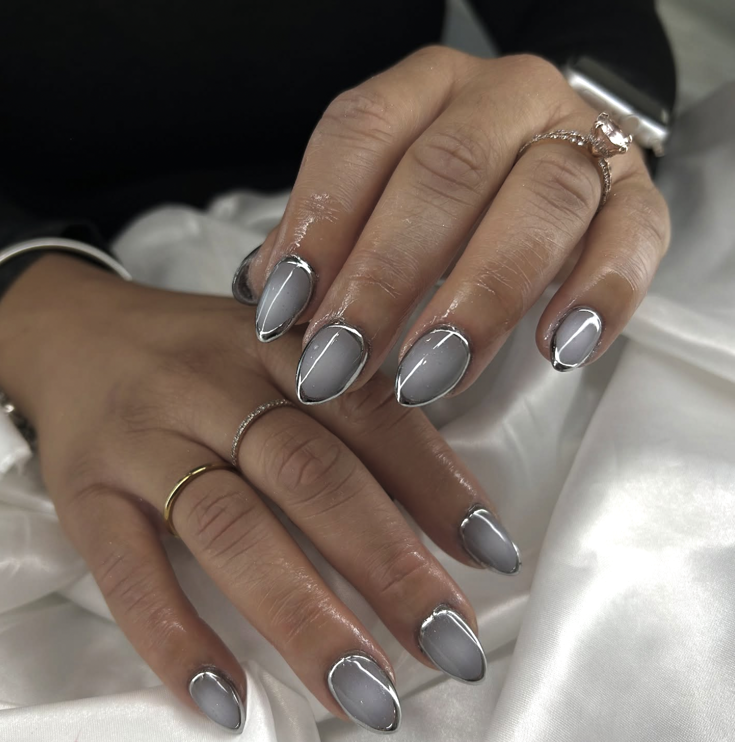 Charcoal aura nails with luminous silver centers.