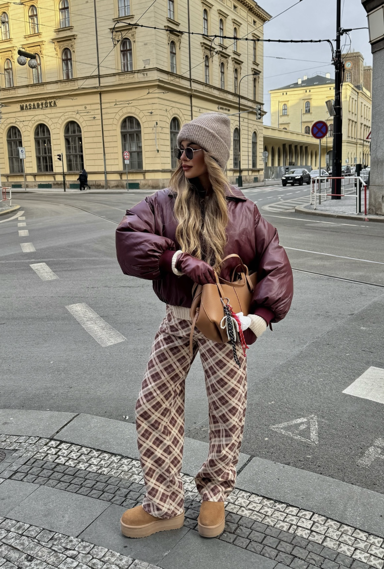 Burgundy puffer jacket, checked trousers and gray beanie with tan UGG shoes.