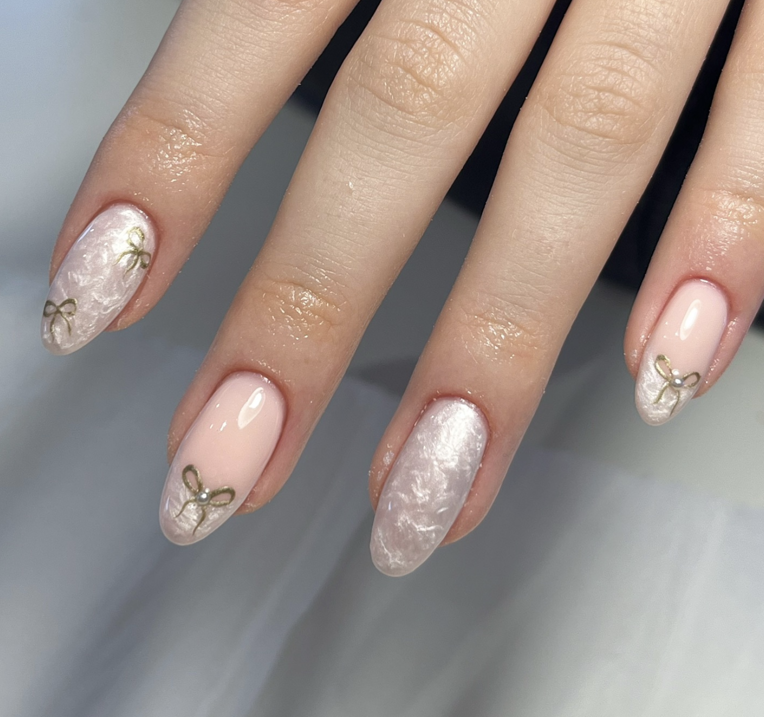 Sheer Christmas nails with delicate bows and tiny pearl accents