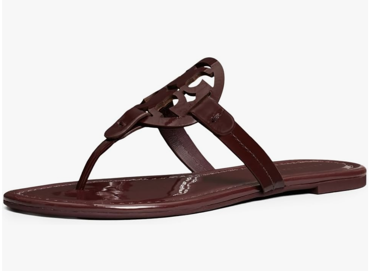 A pair of black leather Tory Burch Miller sandals featuring the iconic laser-cut logo medallion and a slim sole.