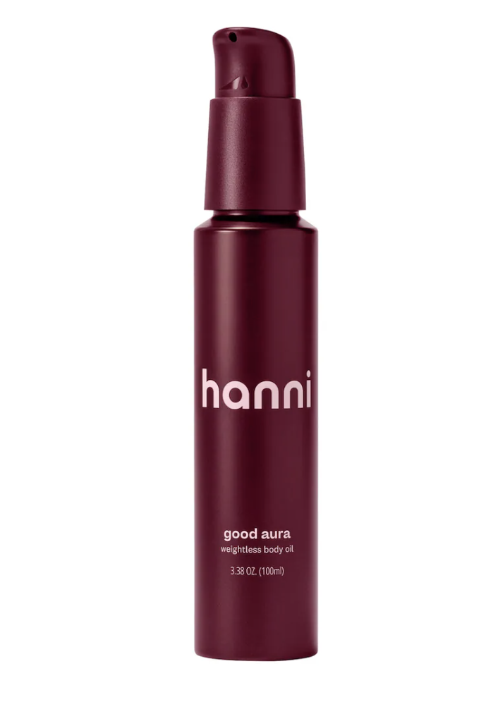 A sleek, deep burgundy bottle of Hanni Good Aura Weightless Body Oil with white text, positioned against a clean white background.