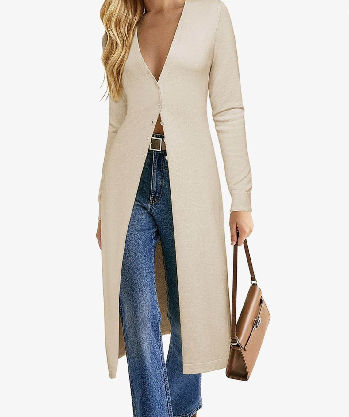 A woman wearing a longline beige knit cardigan over a white top and high-waisted blue jeans, holding a brown leather bag—a perfect cozy yet professional layer for a hybrid work capsule wardrobe.