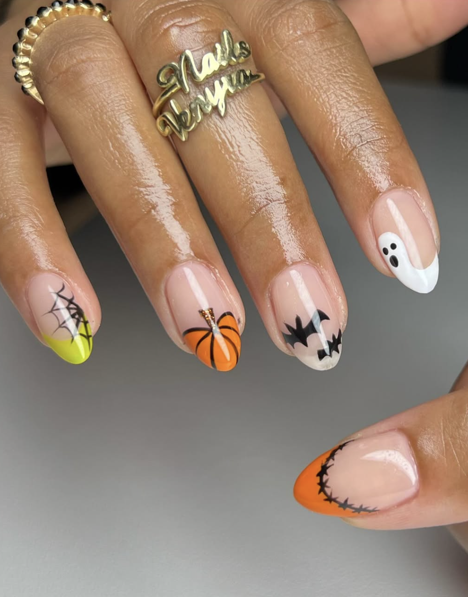 Short natural nails with thin orange French tips and a tiny pumpkin accent