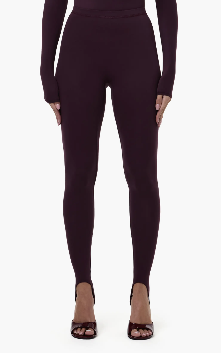 Black stirrup leggings styled with open-toe heels, a key piece for the spring 2026 equestrian-chic trend.