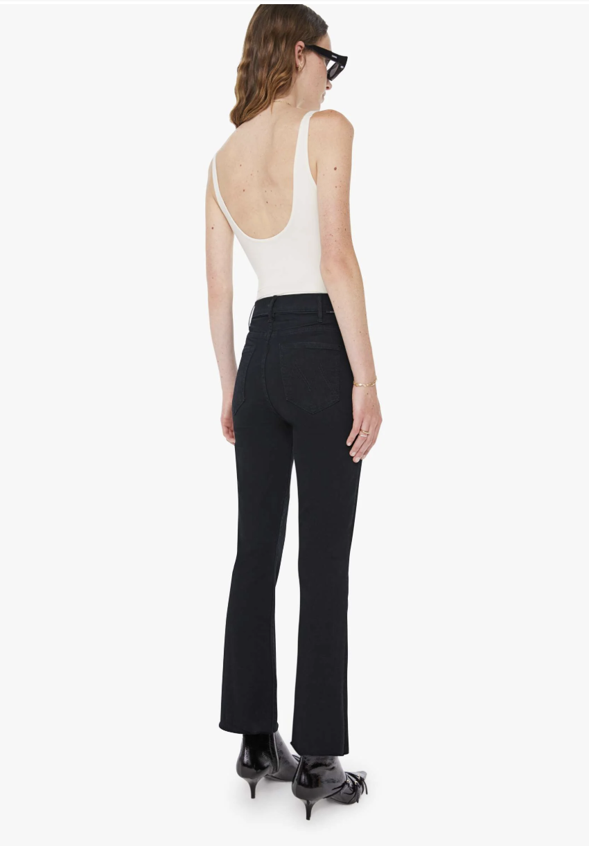 Rear view of an editor-recommended pair of high-waisted flare jeans with high-set pockets designed to lift and shape a flat bottom.