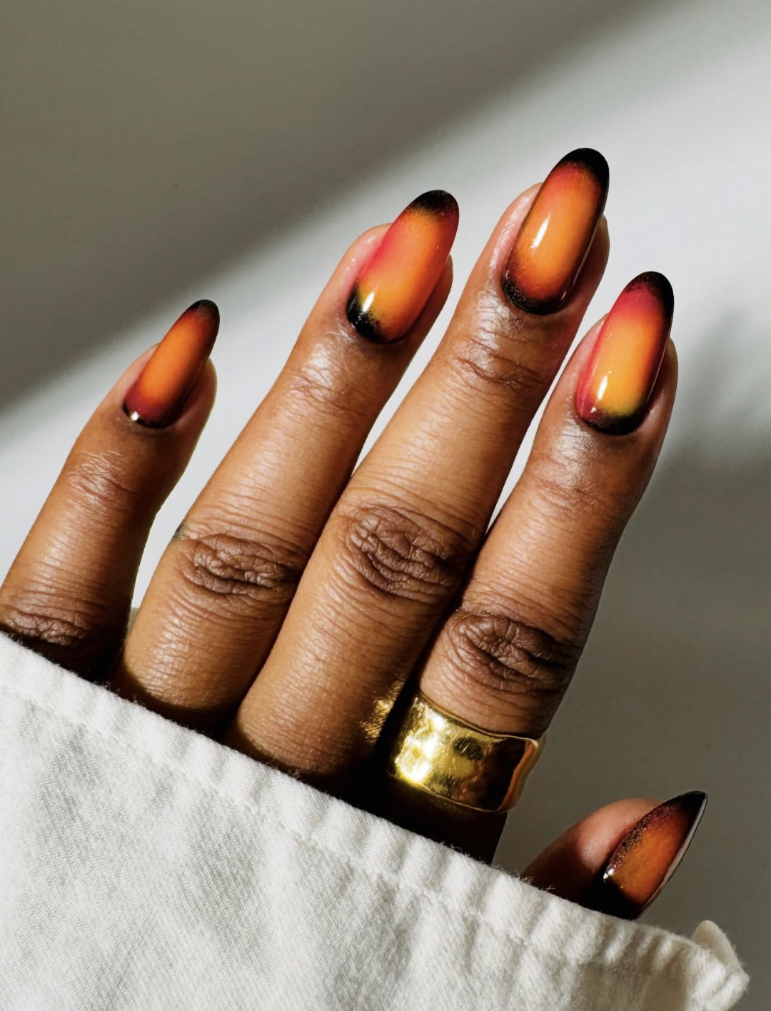 Glossy burnt-rust terracotta nails styled as an early-fall manicure.