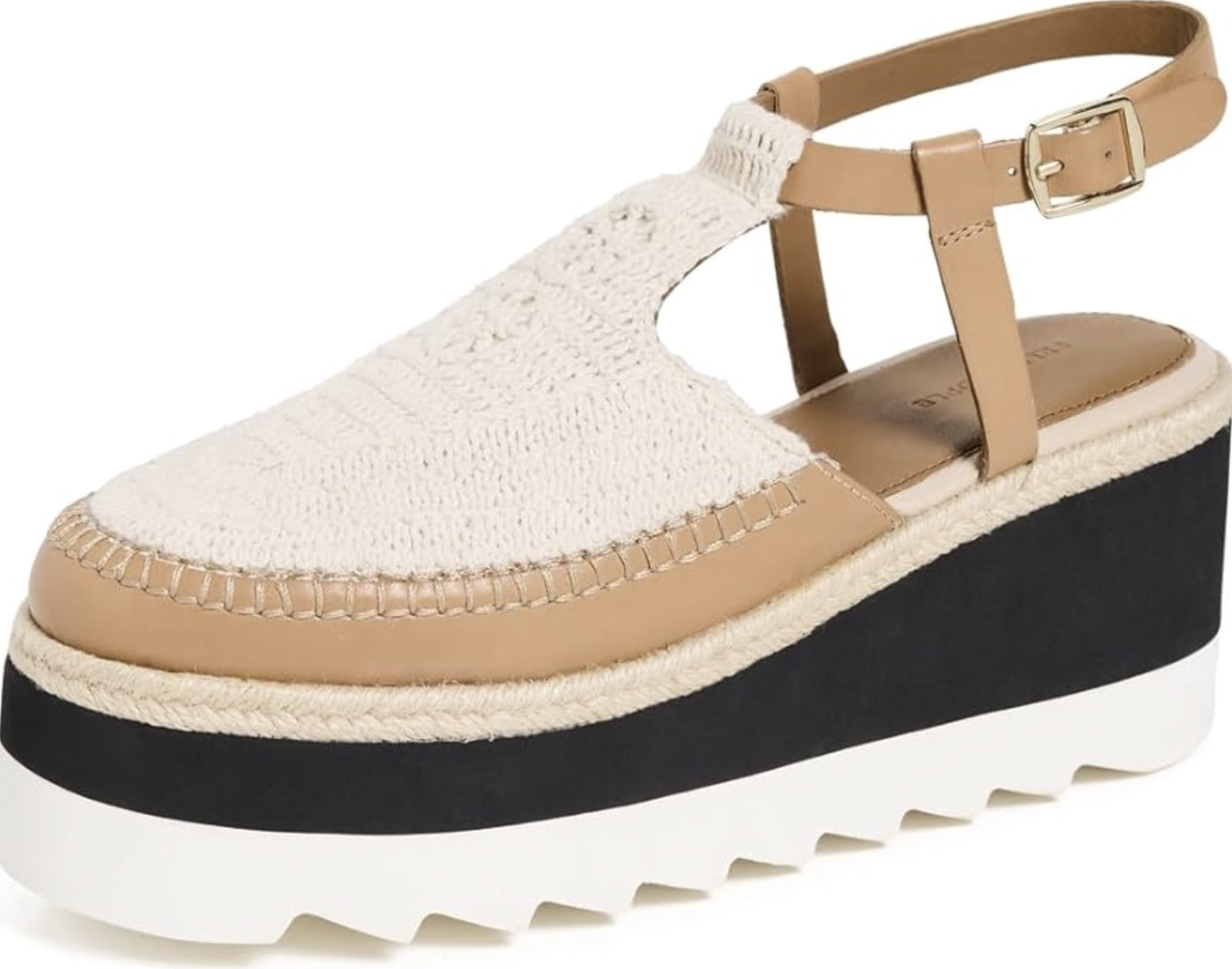 A pair of cream and tan platform espadrilles by Free People with a textured woven toe, tan leather straps, and a thick black and white foam sole.