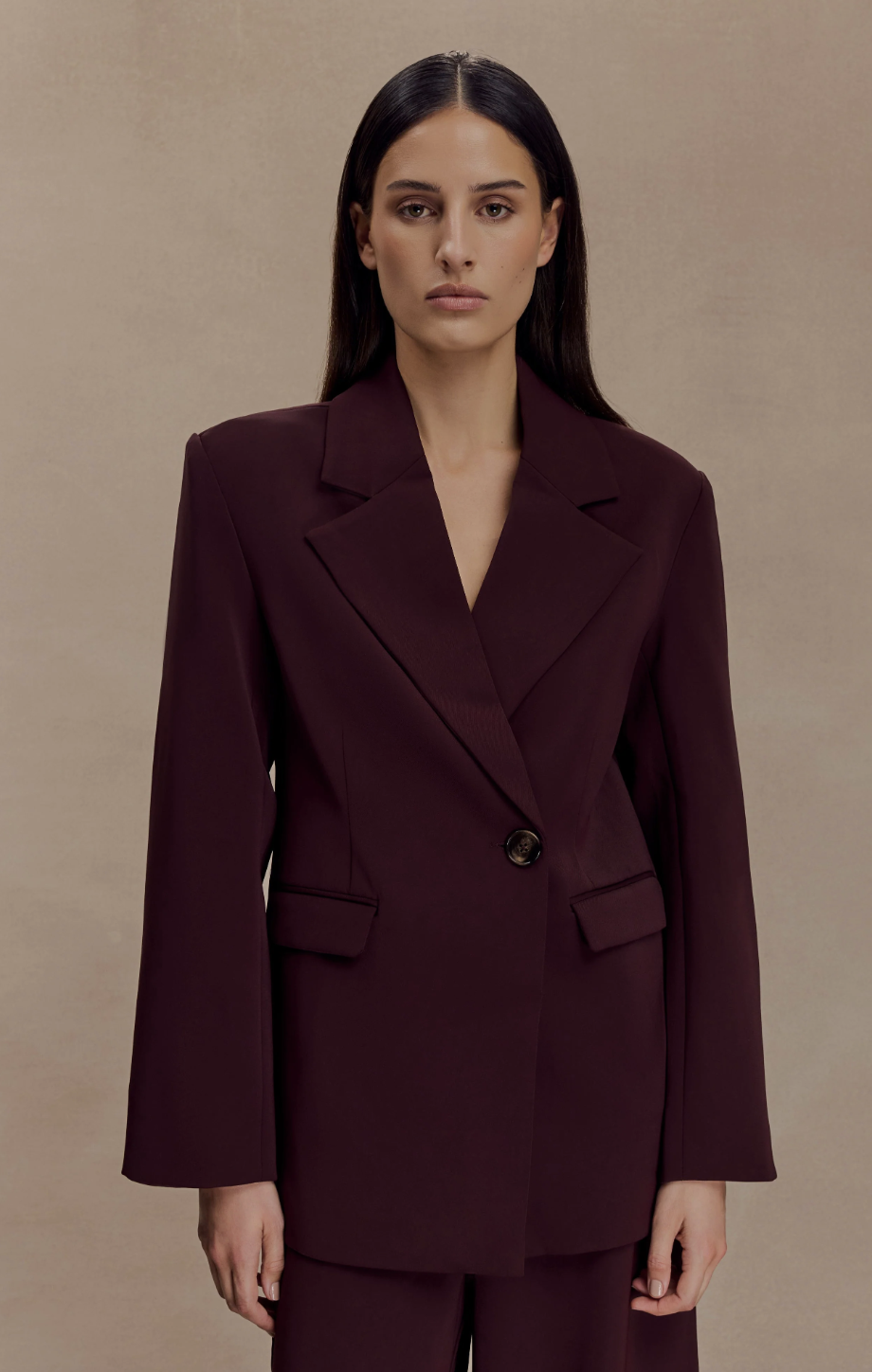 Front view of a model wearing the Meshki Mateo oversized blazer in a deep plum color with matching trousers.
