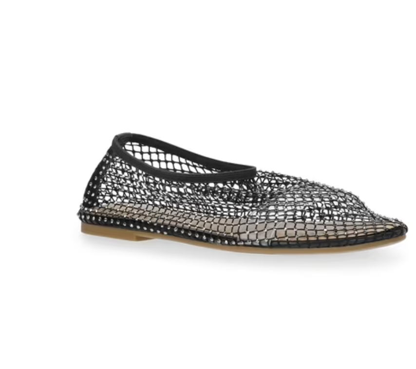 A side profile product shot of a trendy pair of black mesh ballet flats featuring an open-weave sheer fabric, a classic rounded toe, a sleek black trim, and a low-profile flat tan rubber sole.