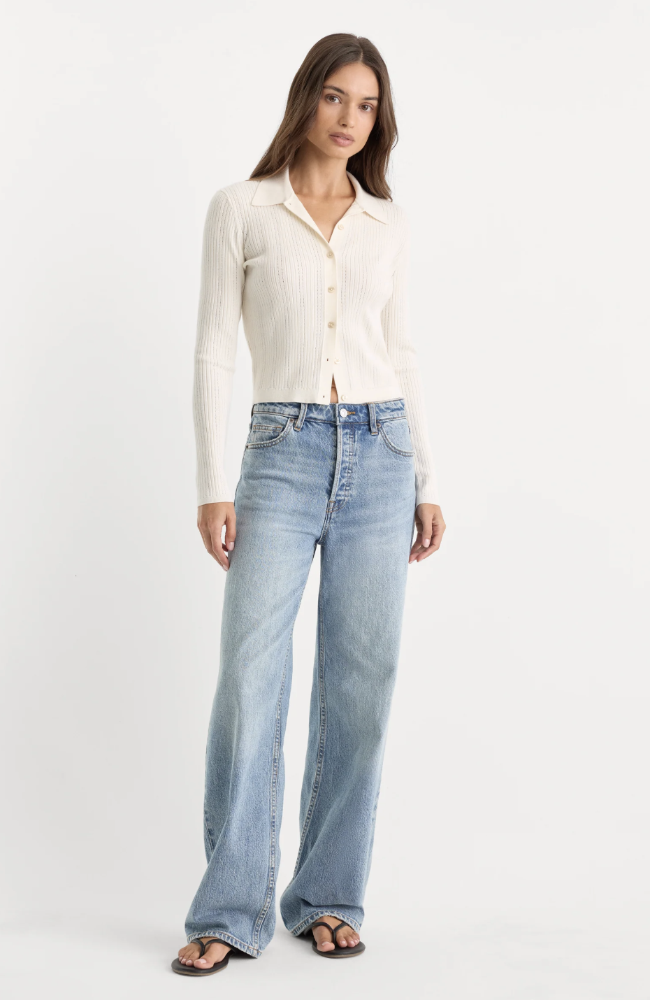 Light-wash relaxed wide-leg jeans styled with a cream polo top.