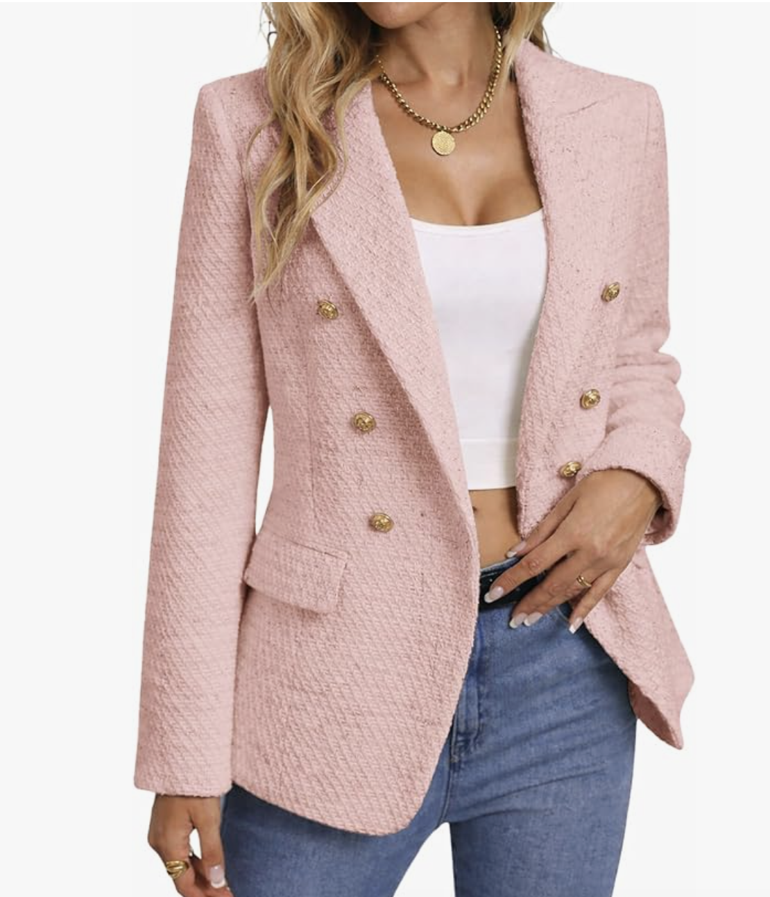 A woman wearing a pink tweed plaid blazer with gold buttons over jeans, styled as a dressy layer for what to wear with a spaghetti strap dress.