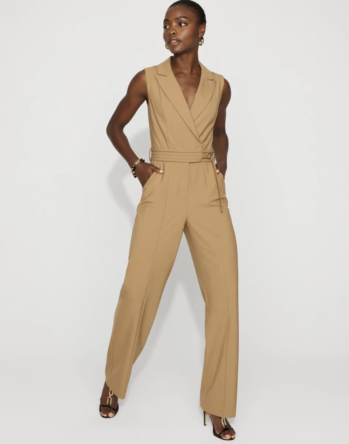 A professional work outfit featuring a tan tailored blazer jumpsuit, a perfect one-piece solution for styling with white sneakers.