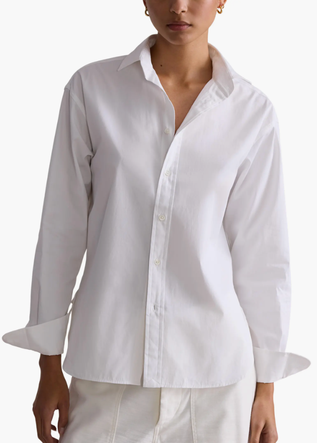 Woman wearing a crisp white Polo Ralph Lauren button-down shirt with turned-back cuffs and white trousers.