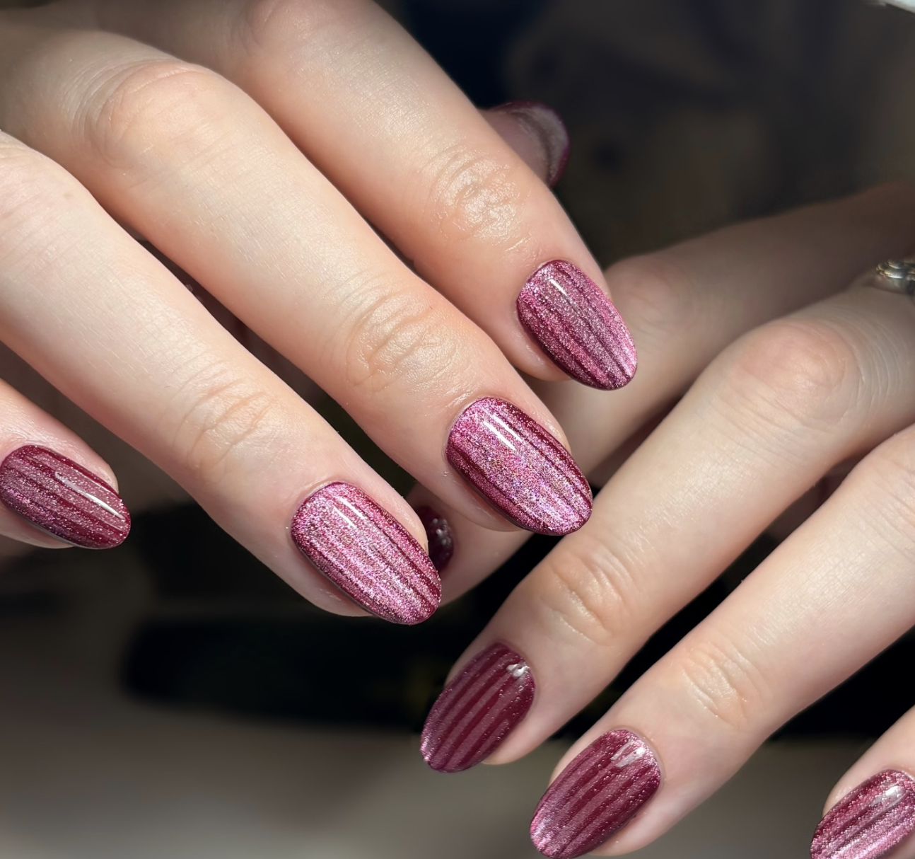 Long, oval-shaped nails showcasing a rich, textured velvet magenta base with a soft, multidimensional magnetic shimmer and a glazed finish.