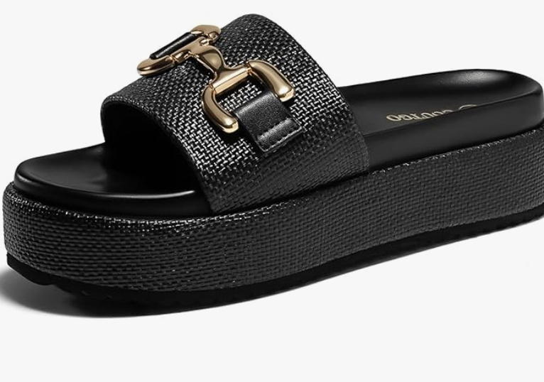A product shot of black platform espadrille sandals with a gold buckle, an editor-recommended choice for adding height and balancing the silhouette of extra-long wide-leg jeans.