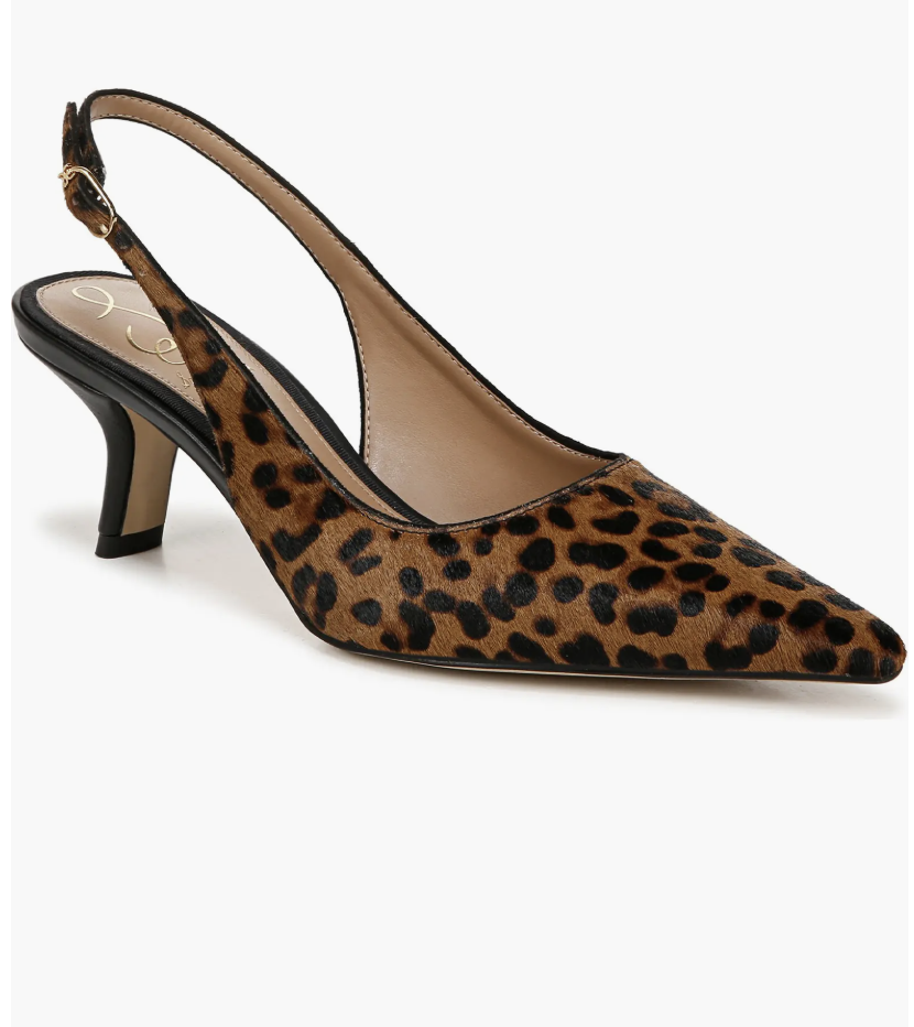 A chic mirror selfie showing how to style black capris with leopard print slingbacks and a long leather trench coat.