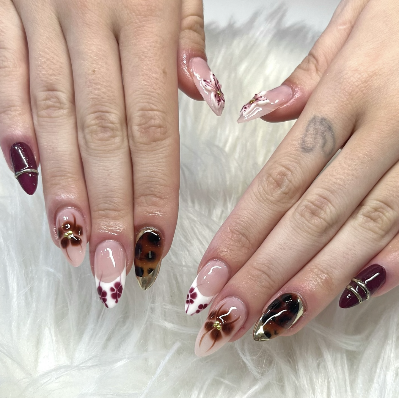 Long almond-shaped nails with a glossy tortoiseshell design featuring blended layers of warm amber, honey brown, and deep black.