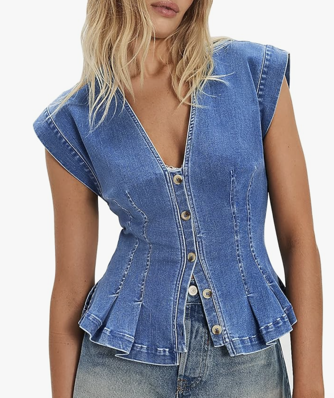 A front profile of the Nitzana denim vest in a medium wash, featuring a V-neckline, button-down front, and a cinched peplum waist styled with high-waisted jeans.