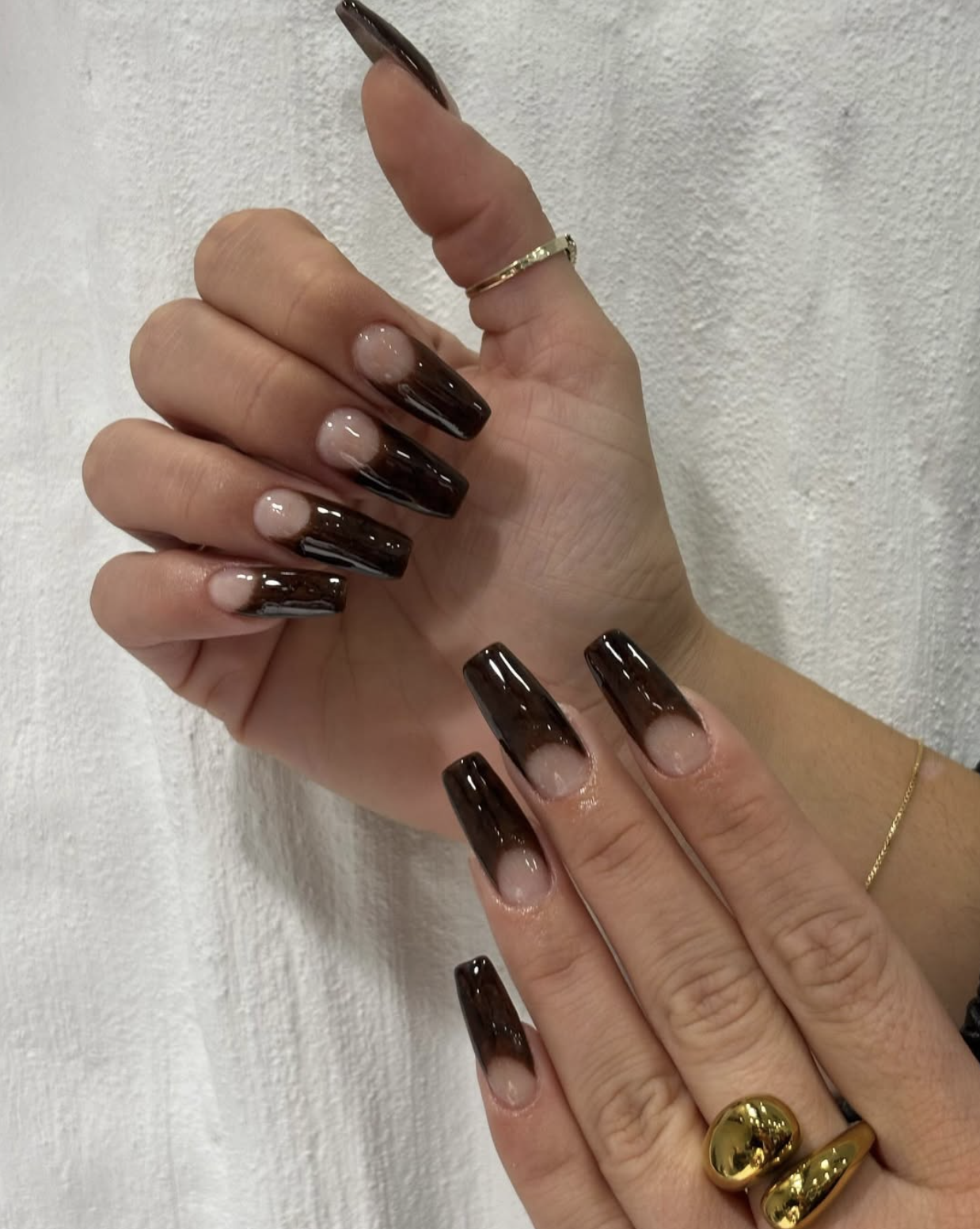 Short nails with chocolate brown French tips over a sheer nude base