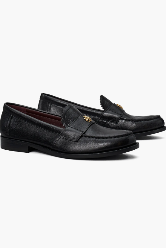 Close up of a pair of polished black leather loafers with gold hardware, a staple footwear choice for poetcore outfits.