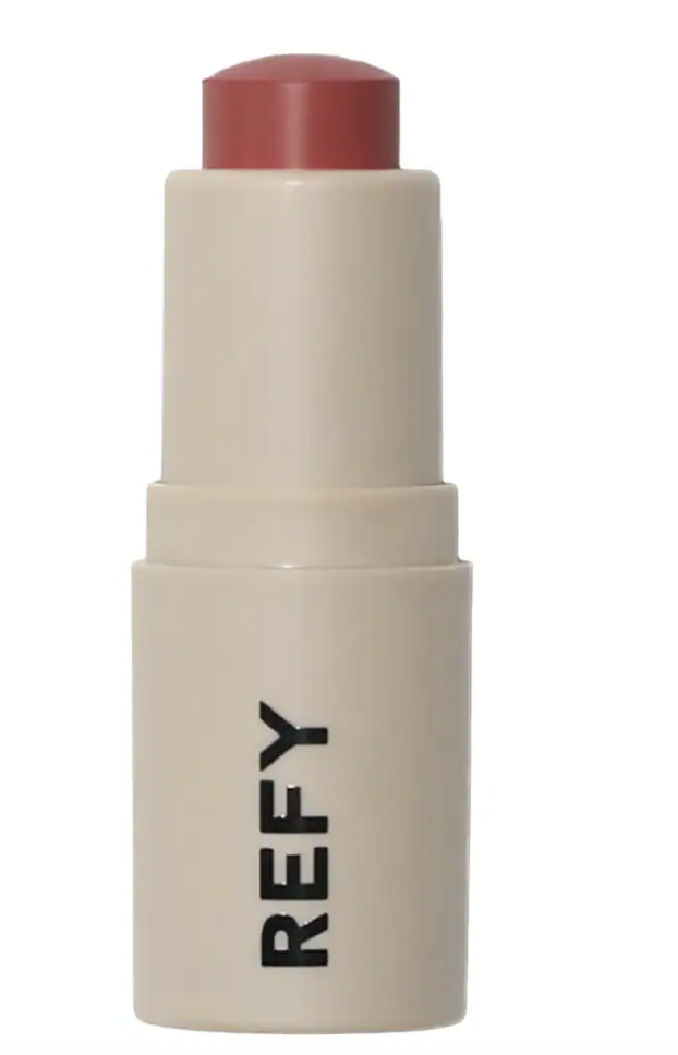 A tube of REFY Lip Blush, a weightless cream lip product used to create the blurred, 'Just Smooched' lip look featured in 2026 beauty trends.