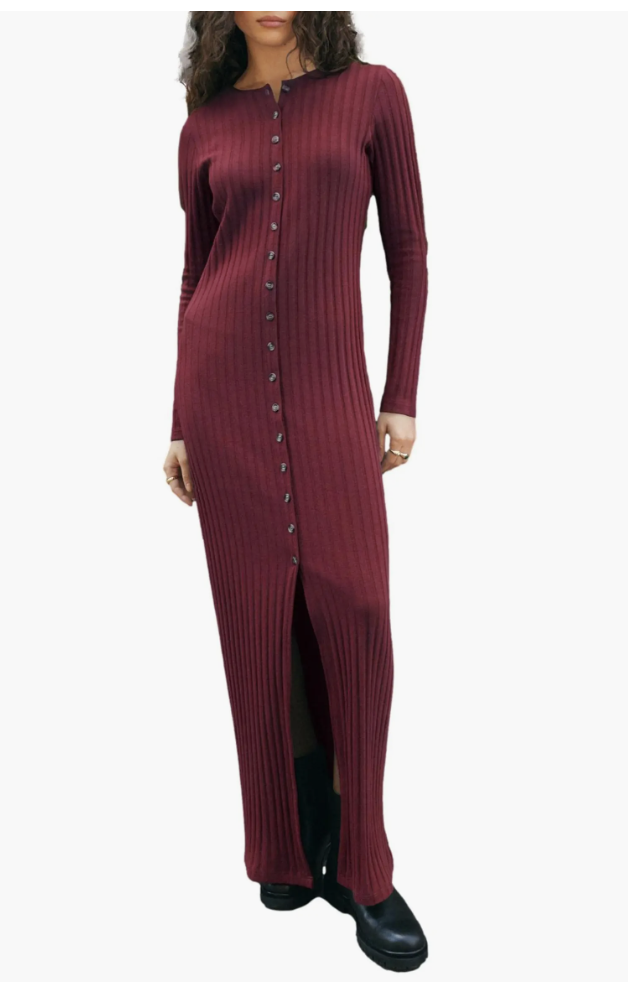 A woman wearing a long burgundy ribbed-knit column dress featuring side button details and styled with black boots.