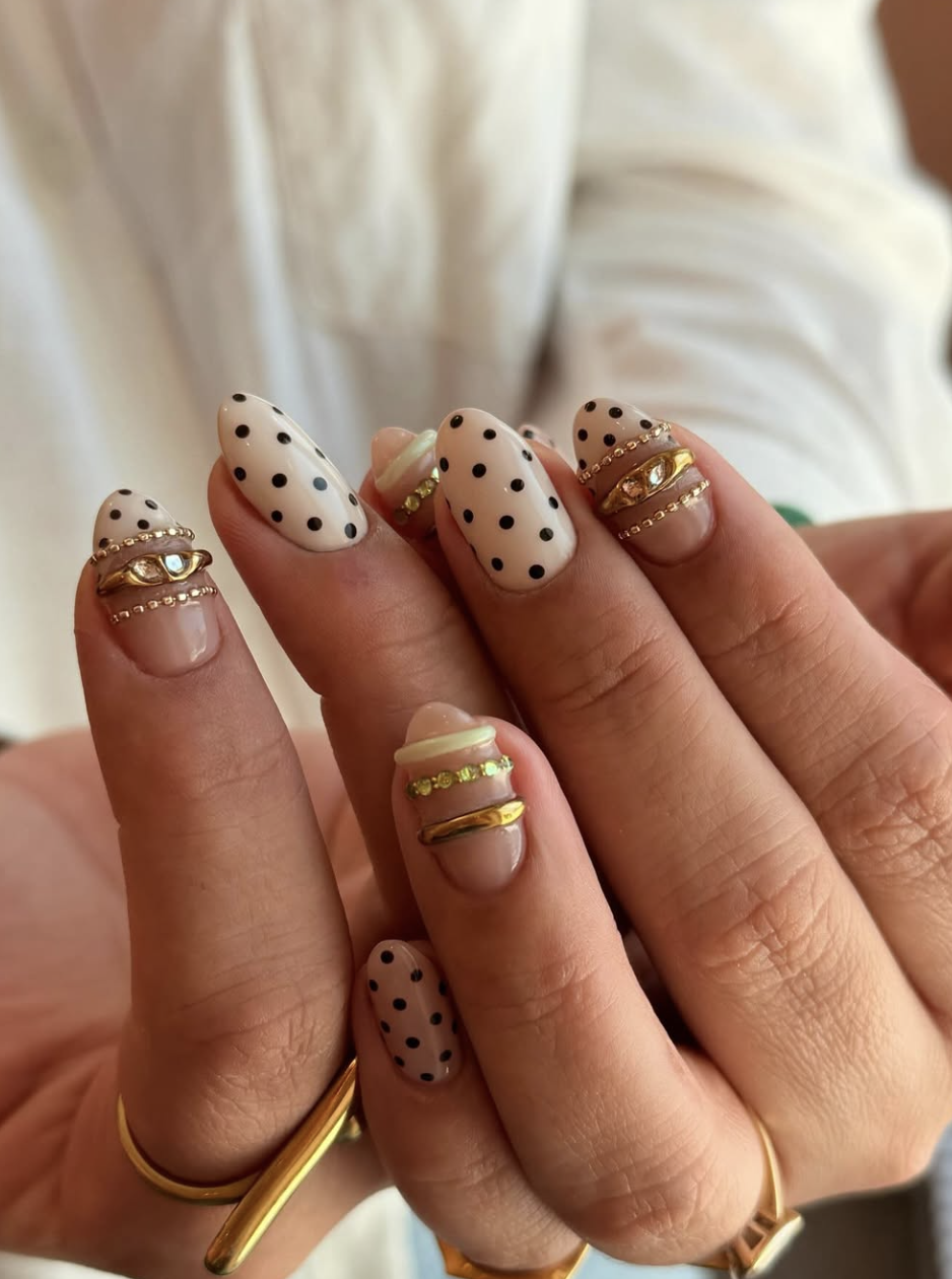 Almond-shaped nude nails with ultra-fine 3D gold wire bands and tiny shimmering gold glitter accents.