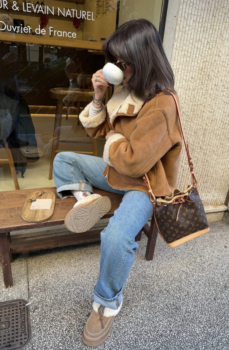 shearling-trim jacket and cuffed blue jeans with fluffy-collar brown shoes.