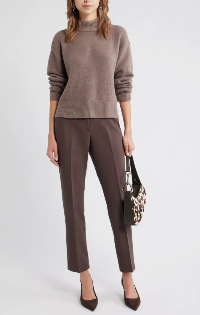 A woman wearing taupe cigarette-style pants with a matching sweater to demonstrate a tonal monochromatic look with brown trousers.