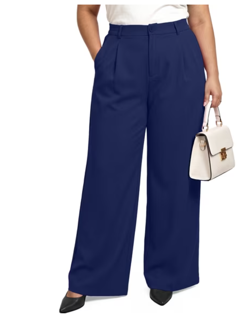Woman wearing navy high-waisted pleated wide-leg trousers with a white top, black pumps and a cream top-handle bag.
