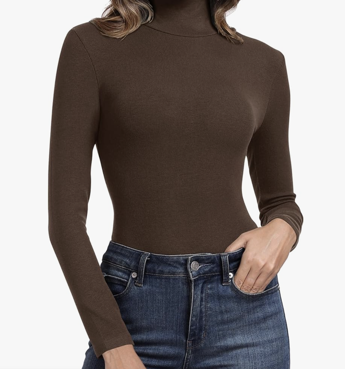 A woman wearing a chocolate brown ribbed turtleneck tucked into high-waisted blue jeans.