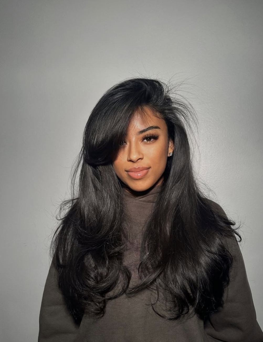 Woman wearing wispy long curtain bangs with soft face-framing movement