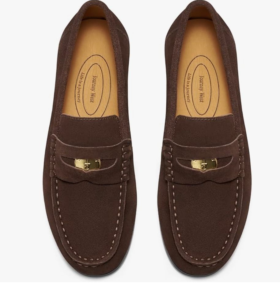 A pair of dark brown suede slip-on driving loafers with a classic penny loader strap and visible white stitching, designed for a comfortable spring capsule wardrobe for women in their 60s.