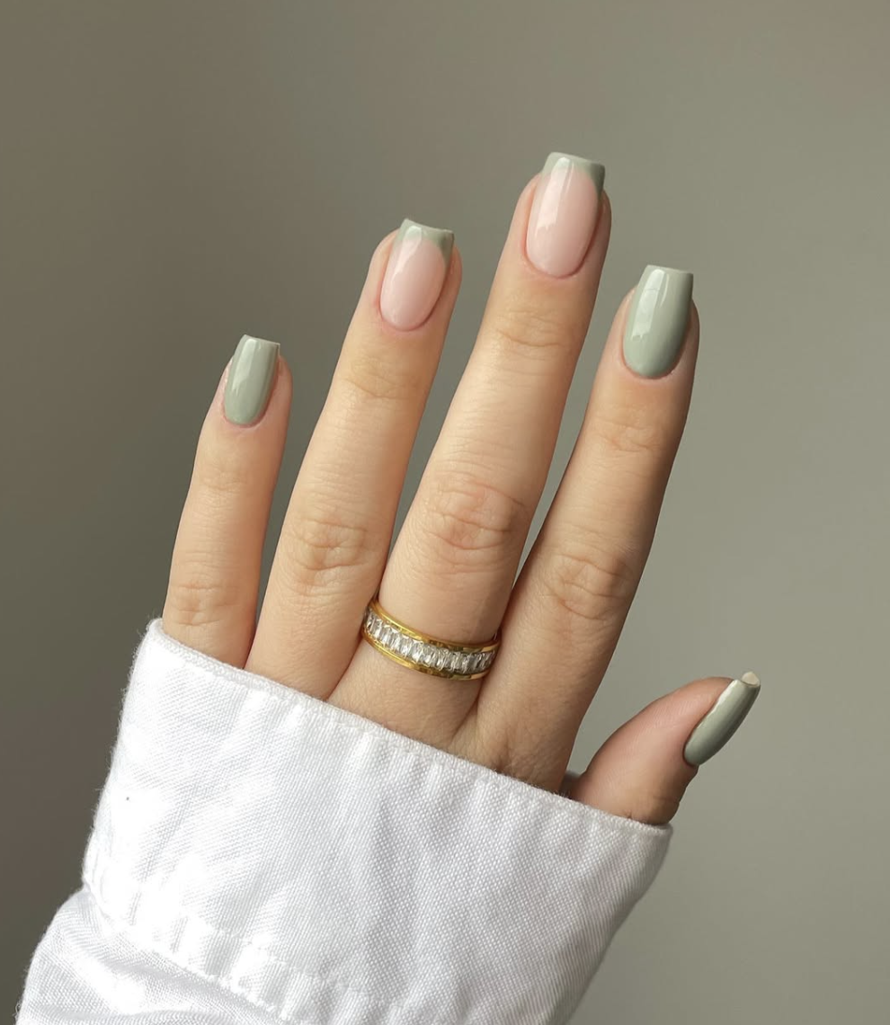 A close-up of almond-shaped nails with a sheer nude base and a very thin, delicate mint green line along the tips.