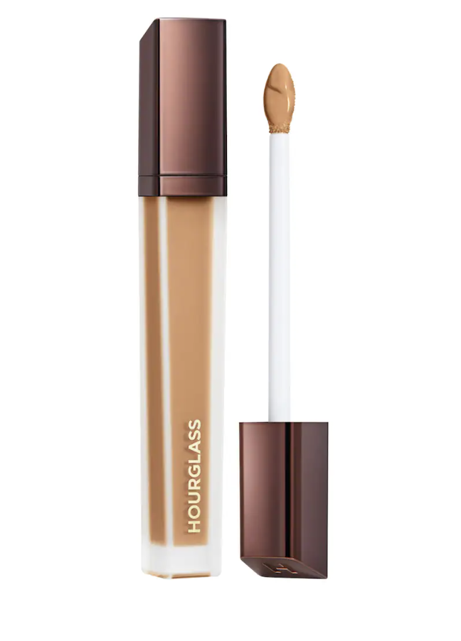 A tube of Hourglass Vanish Airbrush Concealer with a bronze cap, featuring a clear window showing the liquid formula and the applicator wand pulled out.