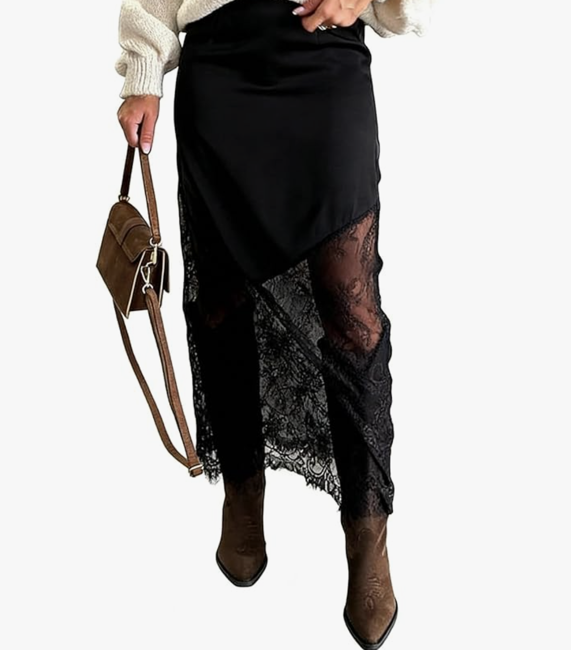 Close-up of a black lace midi skirt with a sheer floral pattern and scalloped hem, styled with brown leather cowboy boots and a matching crossbody bag.