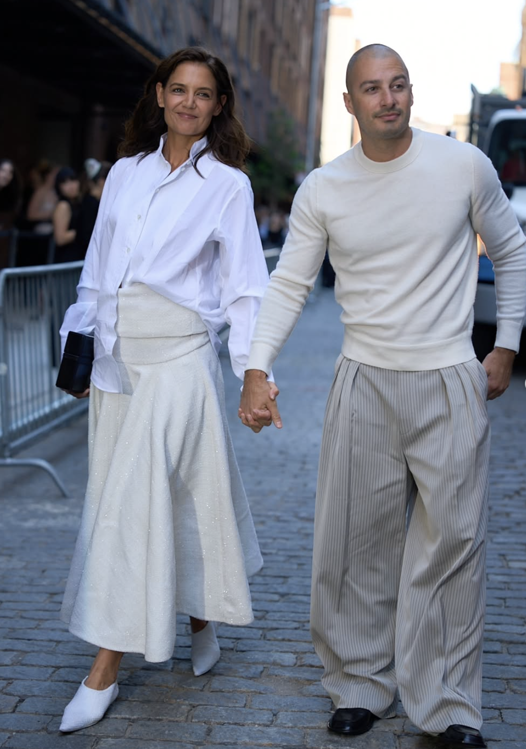 Katie Holmes wearing an oversized white button-down shirt, cream midi skirt and white pointed shoes in New York.