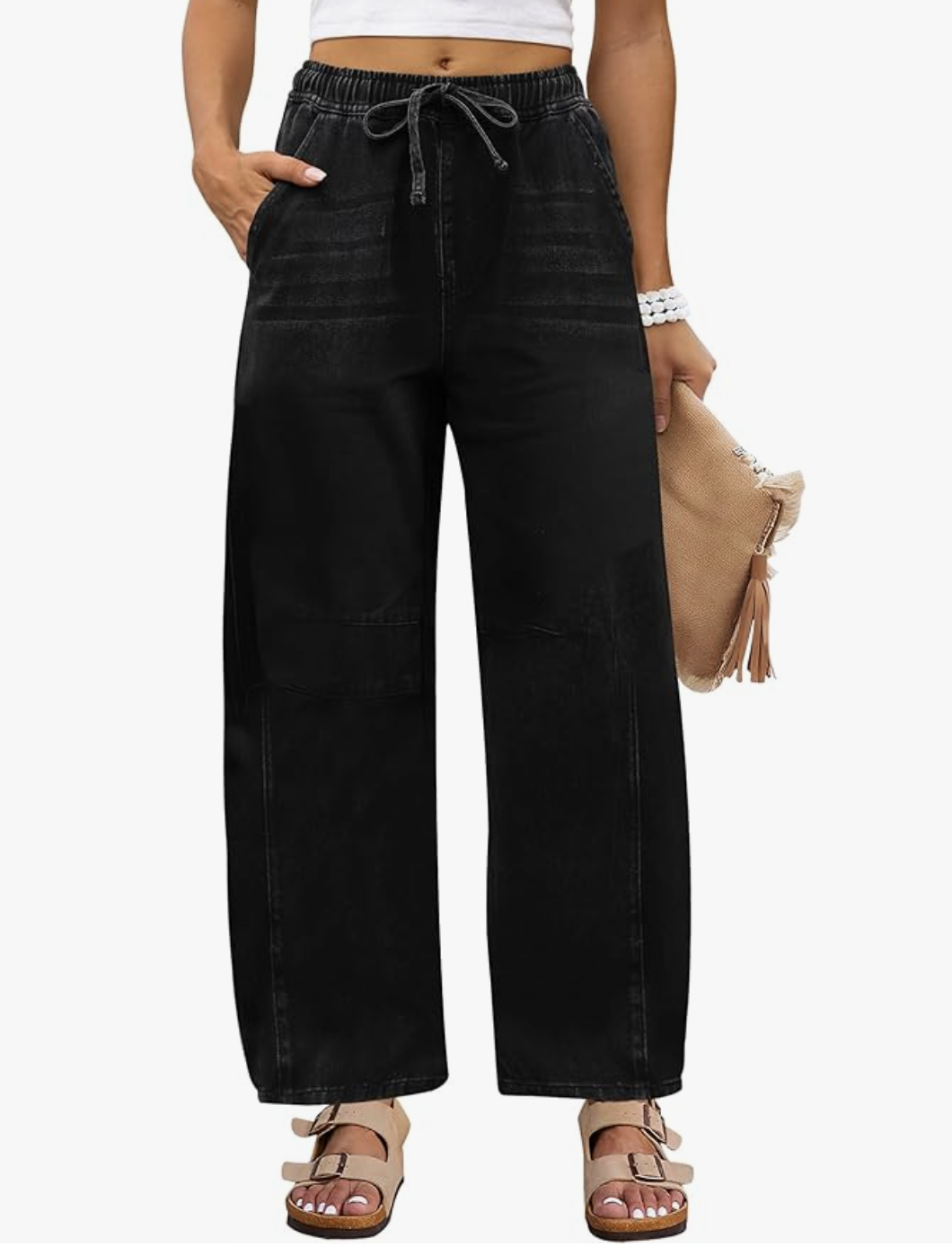 A woman wearing black High Waisted Barrel Jeans from Amazon, featuring a curved leg silhouette and styled with tan slide sandals.
