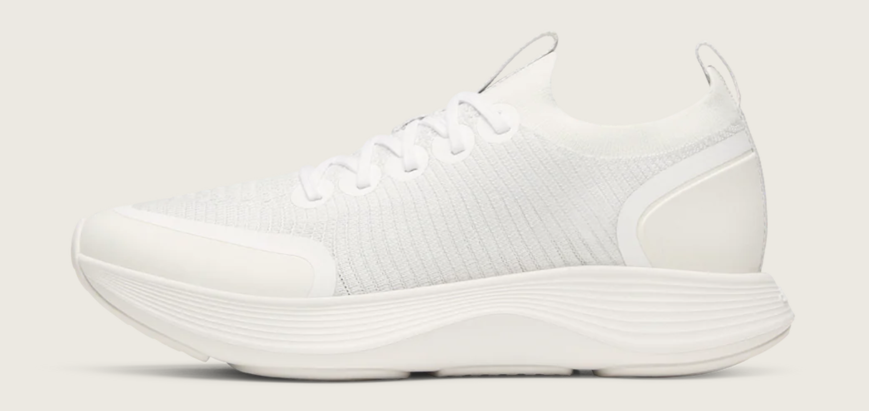 Side profile of the Allbirds Women's Strider in crisp white, featuring a sleek, athletic silhouette and supportive cream-colored sole