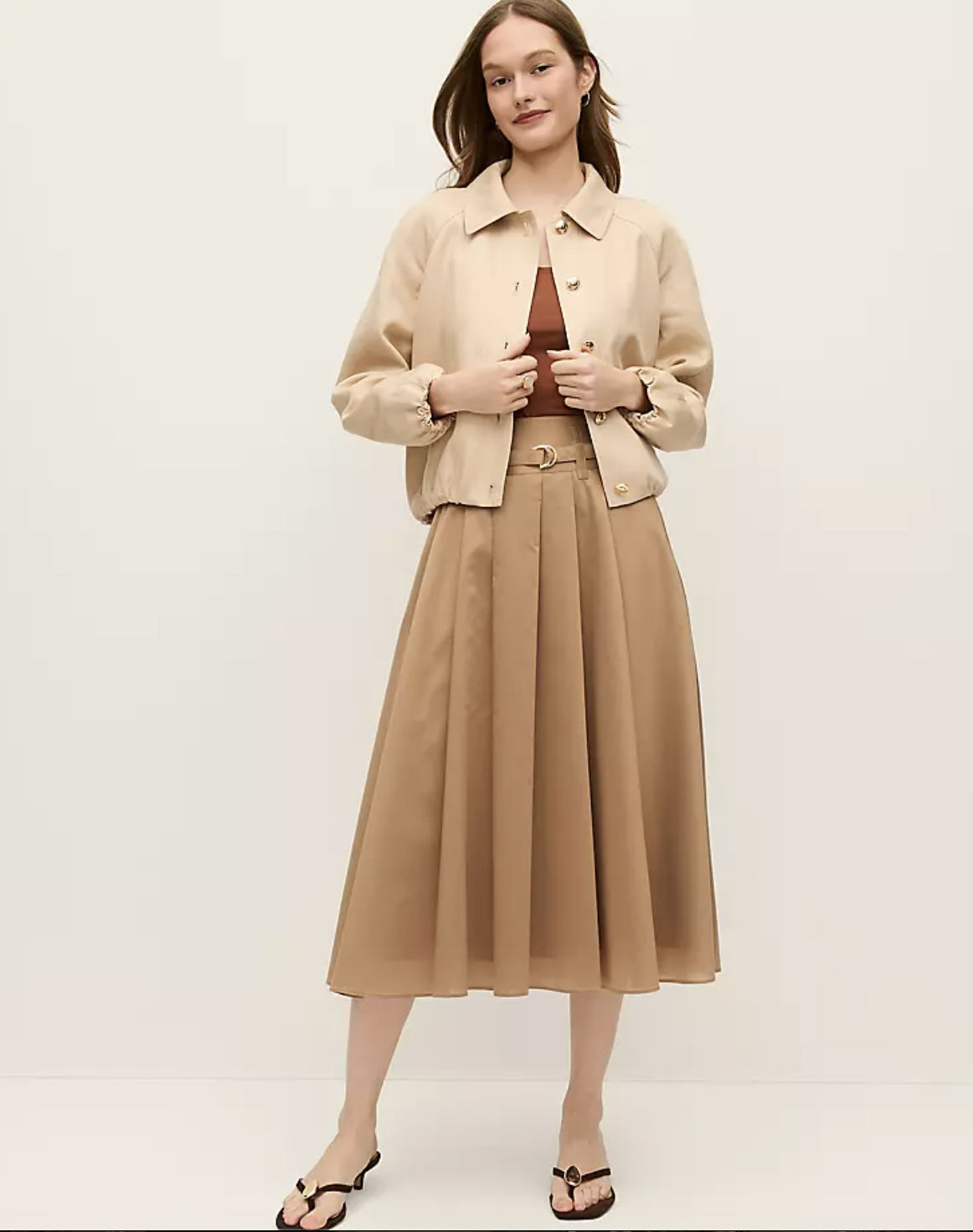Professional stylist's pick for the Ann Taylor Belted Pleated Midi Skirt in Classic Tan, styled with a tan cropped jacket and dark sandals for a monochromatic spring look.