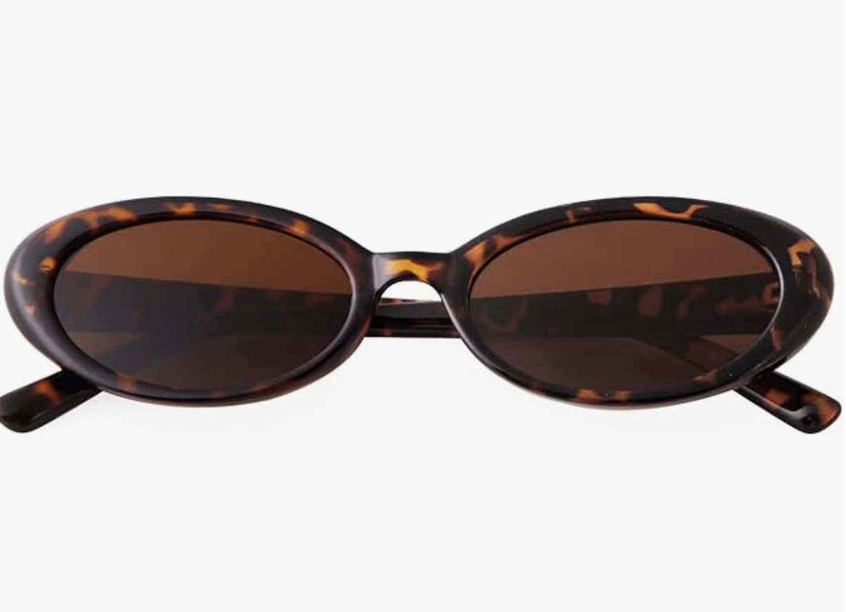 Slim oval sunglasses in a classic 90s tortoise shell pattern, a top eyewear trend for 2026.