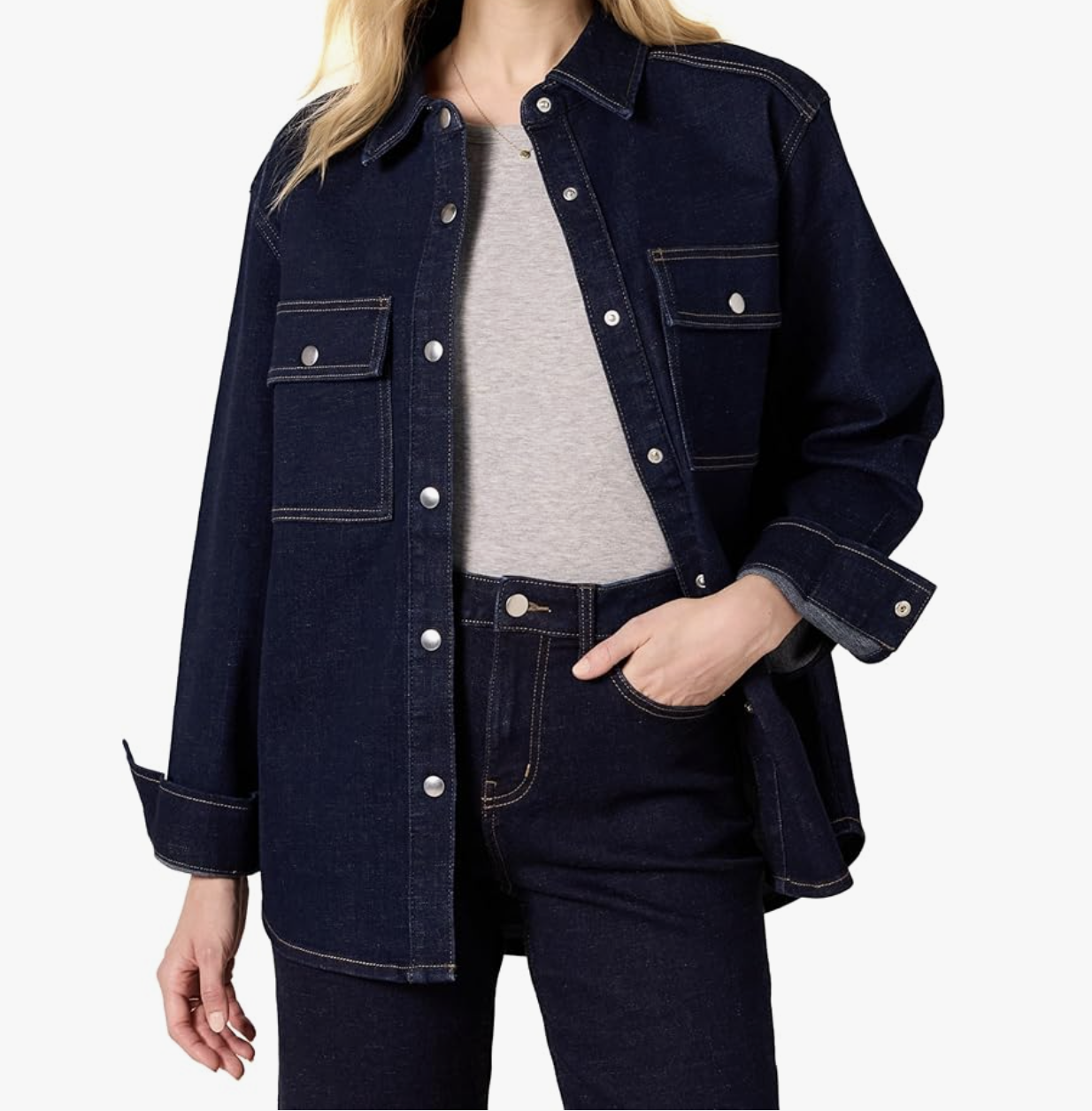 Close-up of a woman wearing a structured dark wash denim shirt jacket over a grey t-shirt and matching bootcut jeans.