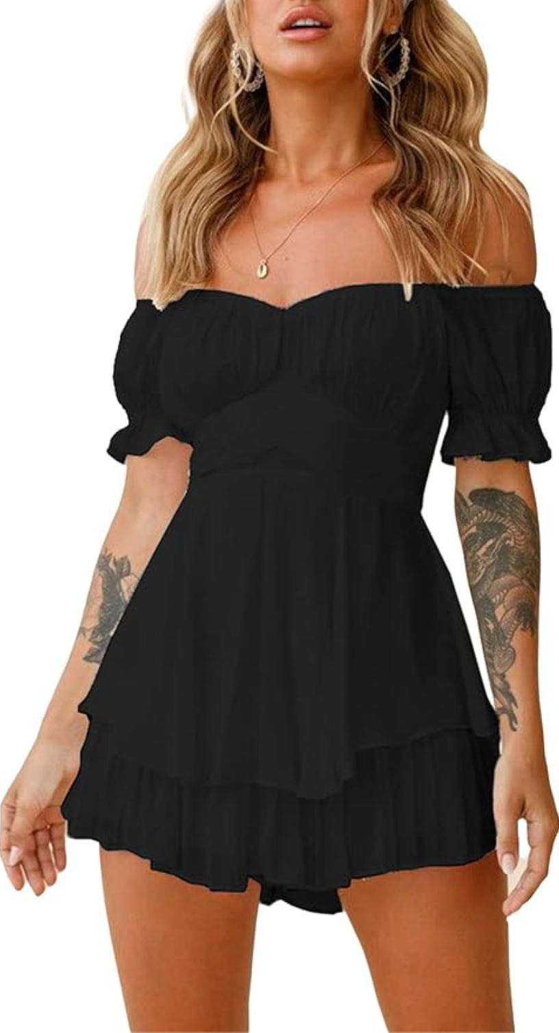 A woman wearing a black off-the-shoulder boho romper with a ruffled neckline and hem, styled for a casual summer look.