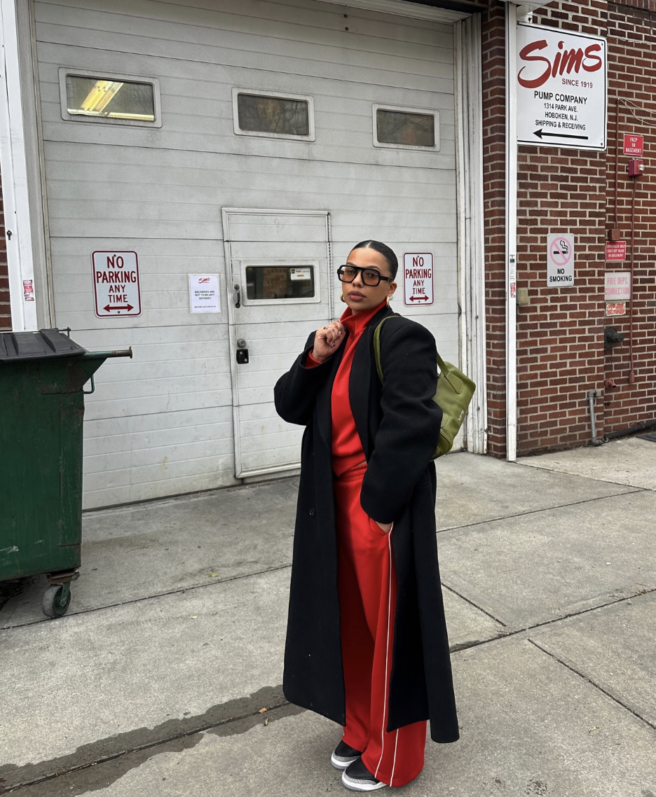 Professional style hack: Tylauren styling red Adidas Firebird track pants with a dramatic floor-length black overcoat and a red turtleneck for a sharp, high-fashion Downtown Edge look.