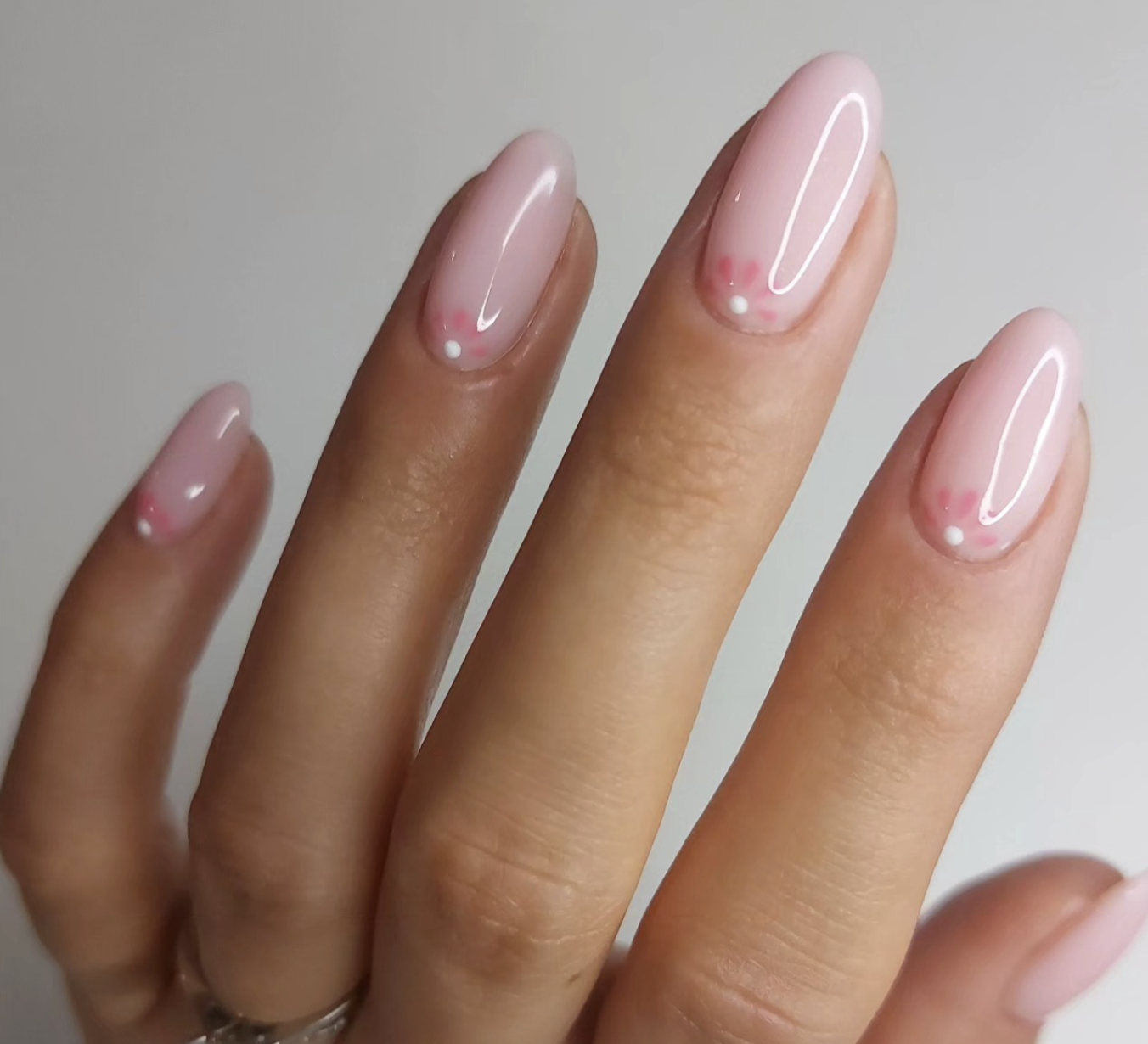 Long almond nails with a soft pink aura gradient and tiny 3D white droplet accents.