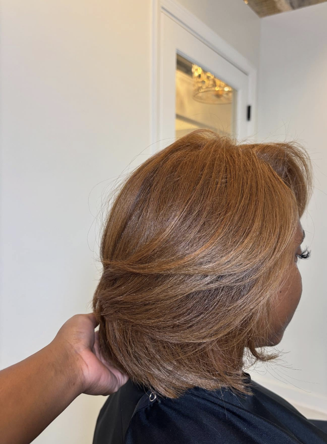 Auburn silk press hair styled in a '90s-inspired layered blowout with movement