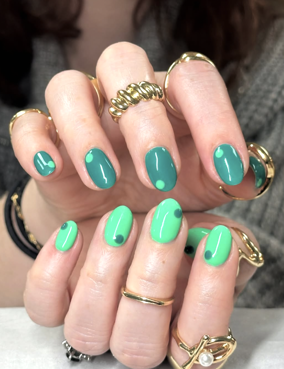 Long, oval-shaped nails featuring a vibrant neon green base coat decorated with matching abstract, layered dark green micro-dots and yin-yang inspired accent details.