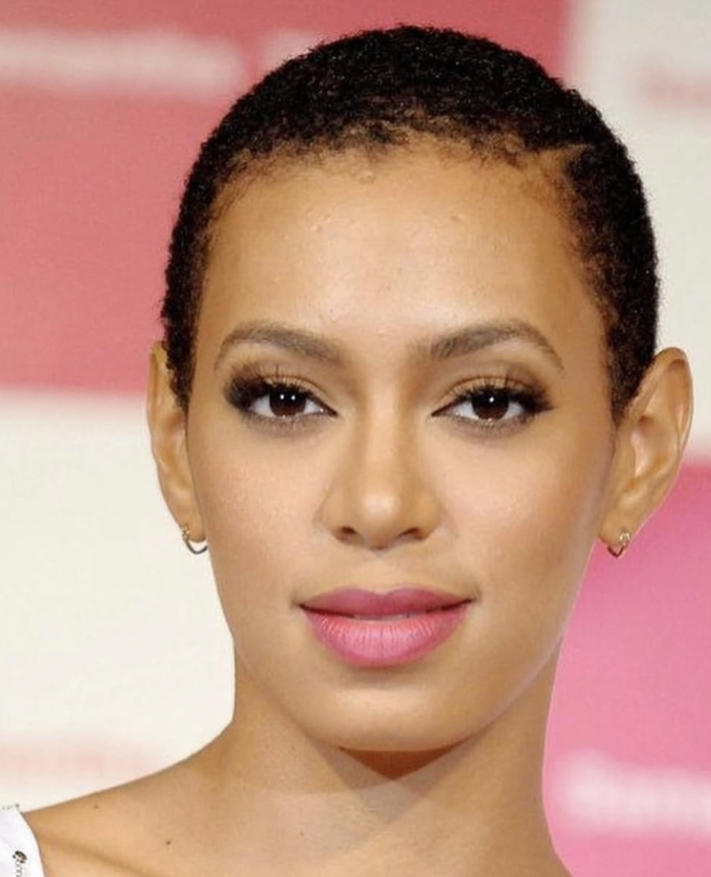 Solange Knowles showcasing a big chop with short, natural hair texture to highlight the balanced proportions of an oval face shape.