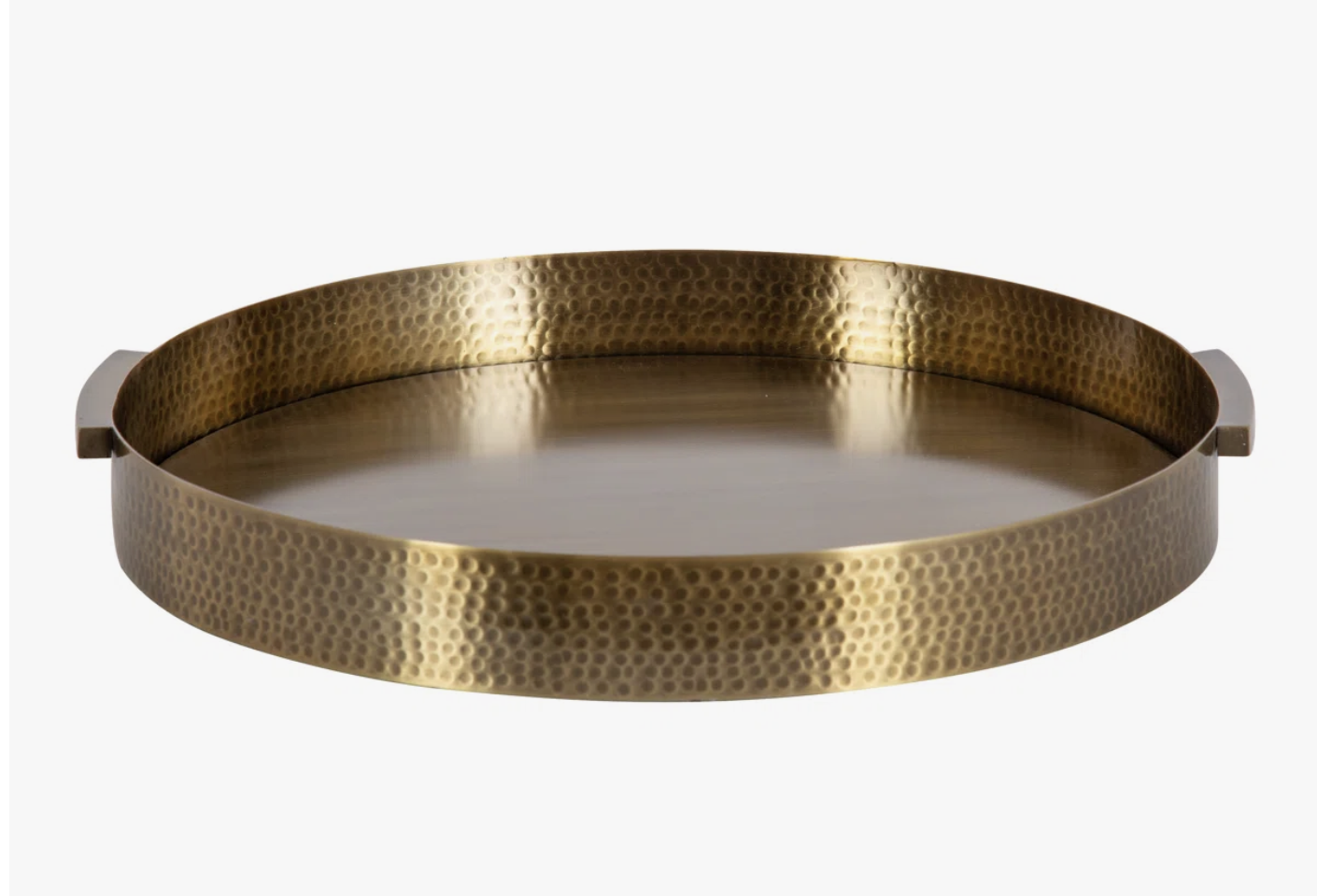 A round brass decorative tray featuring a hammered texture finish and built-in side handles.
