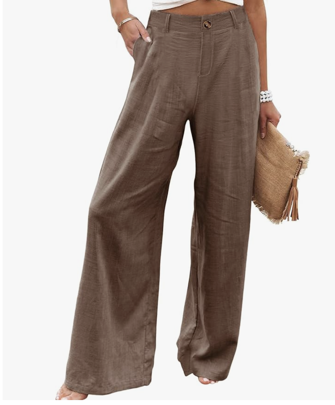 A woman wearing brown wide-leg linen trousers with a high-waisted fit, styled with a tan woven clutch for a summer outfit idea.